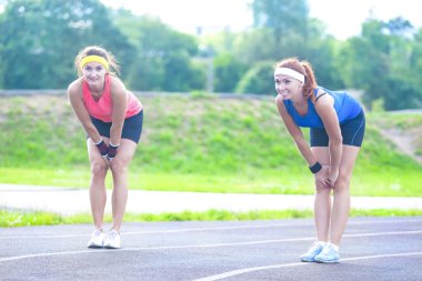 Koşu ve Fitness Konseptleri. Eğitim Öncesi İki Kadın Koşucu Çizgide Duruyor