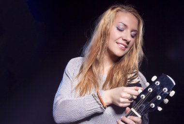 Müzikal kavram ve fikirler. Gitar ile poz Beyaz sarışın kadın