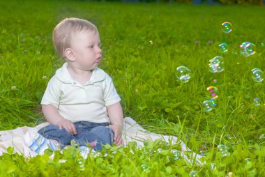 Doğal çim üzerinde açık havada oturup küçük sevimli beyaz Toddler çocuk portresi
