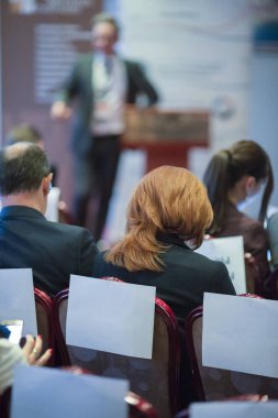 Konferans sırasında seyirciler önünde duran erkek ana bilgisayar hoparlörleri.