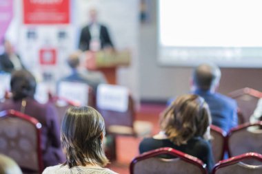 Grup toplantısında büyük ekranın önünde oturan insan