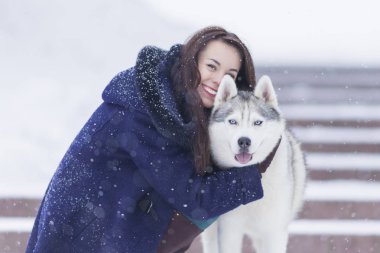 Çok gülümseyen kadın onun Husky köpek dış sarılma portresi.