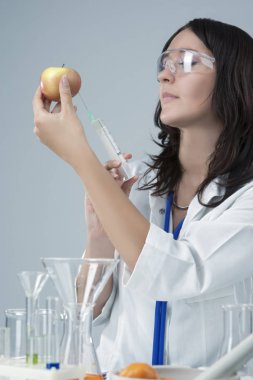 Apple numune laboratuvar için Test sıvı bir enjeksiyon veren kadın laboratuvar personeli