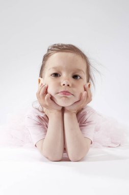 Beyaz karşı pembe elbiseli poz üzgün görünümlü küçük sarışın çocuk portresi