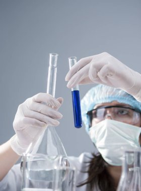 Researching ve bilim kavramları. Yüz maskesi ve koruyucu eldiven deney kadın laboratuvar personeli