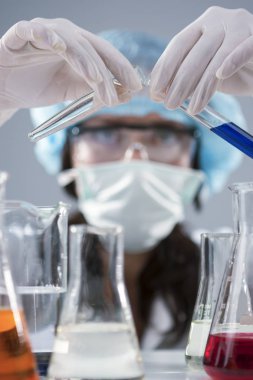 Researching ve bilim kavramları. Kadın laboratuvar personeli yüz maskesi ve koruyucu eldivenler