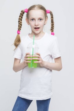 Kupası tutarak ve yeşil suyu içme uzun kuyruklu sürpriz oldukça Beyaz sarışın kız portresi