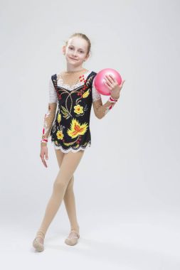 Studio beyaz karşı orta topu ile profesyonel rekabet takım elbise poz kadın ritmik jimnastikçi sporcunun