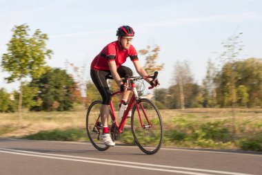 Açık havada bisiklet sürerken yarış kıyafeti giymiş profesyonel bir bisikletçi. Kullanılan tarama tekniği.