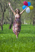 Boldog mosolygó kaukázusi szőke női futó erdő színes hőlégballonok portréja
