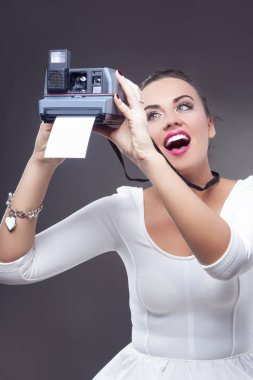 Mutlu gülümseyerek beyaz esmer kadın anlık fotoğraf makinesi ve yazıcı ile portresi