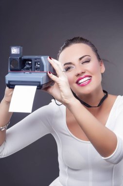 Gençlik yaşam tarzı kavramları. Mutlu gülümseyerek beyaz esmer kadın anlık fotoğraf makinesi ve yazıcı ile portresi. 
