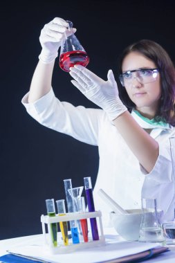 Tıp ve bilim kavramları. Beyaz kadın laboratuvar asistanı renkli kimyasallar laboratuvarında incelenmesi.