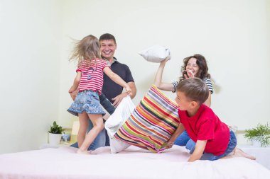 Dört oynak komik yastık savaşı kapalı yatağa sahip genç Beyaz aile