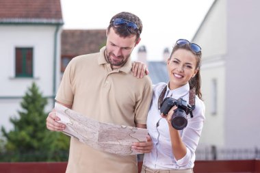 Genç çift şehrin içinden seyahat ve Pictures.Posing harita muayene sırasında alarak