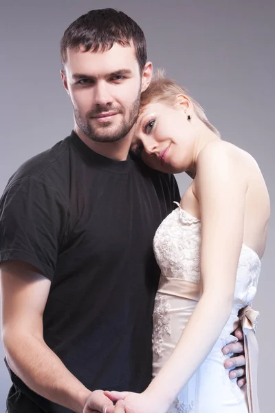 Sensual and Positive Caucasian Couple Posing Embraced Together on Gray.