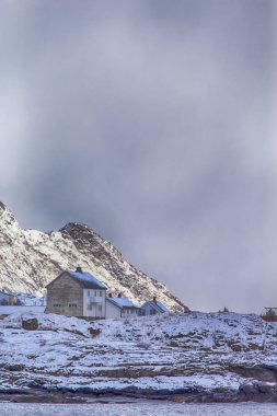 Bulutlu gökyüzü karşı Lofoten Adaları yamaçlarında evlerin satırını ayırın