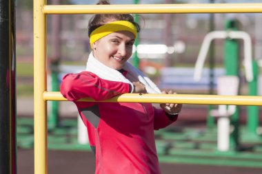 Gülümseyen beyaz kadın sporcunun antrenörü yakınındaki beyaz havlu ile profesyonel kıyafet poz