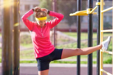 Fitness ve sağlıklı yaşam kavramları. Bacak kasları germe egzersizleri eğitmen açık havada yakınındaki sahip beyaz kadın atlet konsantre
