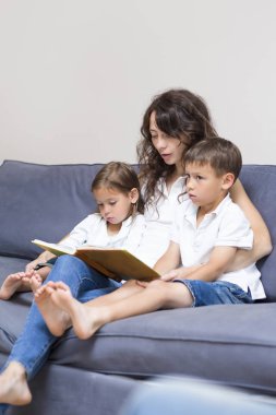 İki çocuk birlikte bir kitap okuma anne