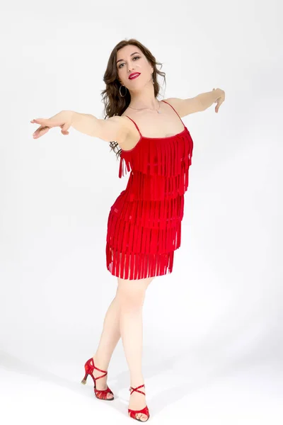 Female Ballroom Dancer in Red Flowing Latin American Dress On White. Demonstrating Rumba Pose