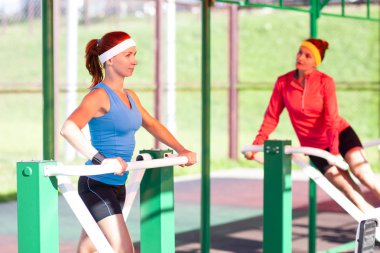 İki etkin sportif kadın açık havada Step eğitmenler üzerinde eğitim