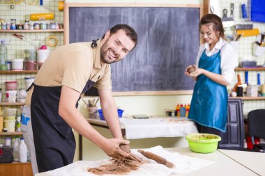 İki profesyonel Ceramists veya Claymakers kil hazırlık atölye tablolarda bir işlemi sırasında