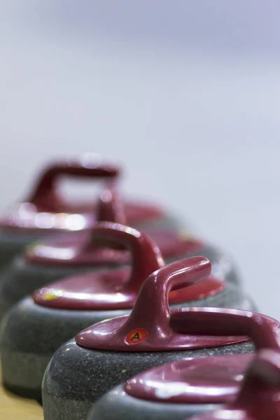 Closeup of Curling Red Handle Stones