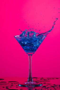 Su damlaları ve içki damlacıkları Yüksek bardaktan dökülüyor