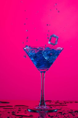 Su damlaları ve içki damlacıkları Yüksek bardaktan dökülüyor