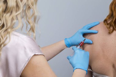 Virüs Kavramları. Kafkasyalı kadın şırıngayla aşı hazırlıyor ve enjeksiyon yapıyor. Virüs Önleme için grip virüsü maskesi takıyor. Gray 'e. Yatay Resim