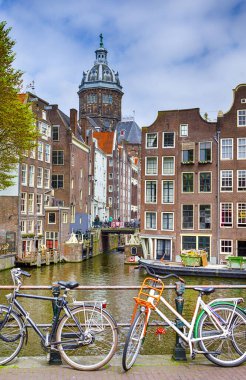 Hollanda 'yı geziyorum. Amsterdam şehri. Bisikletler Amsterdam Kanalı boyunca kuyrukta bekliyor. Dikey Resim Bileşimi