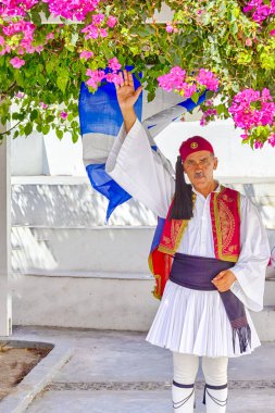 Oia, Santorini - 24 Ağustos 2018: Geleneksel Ulusal Kostümlü Yunan Adamı 24 Ağustos 2018 'de Santorini' deki Oya Köyünde Ulusal Yunan Bayrağına Karşı Ziyaretçileri Karşıladı
