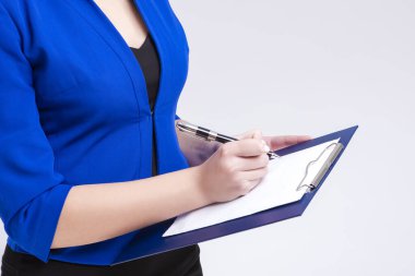 Blue Jacket Poz Veren Meşgul Kadın Girişimci 'nin Kapanışı ve Not Defteri Yazıyor. Stüdyoda beyazlara karşı poz vermek. Yatay Görüntü