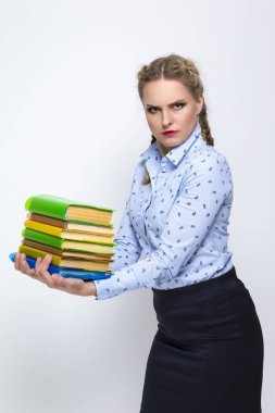 Eğitim Kavramları ve Fikirler. Yüzünde hoşnutsuz bir ifade olan renkli kapaklı kitap yığınıyla beyaz, sarışın kadın pozu. White 'a karşı. Dikey resim