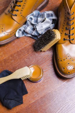 Erkek Ayakkabısı Konsept. Bronz Erkek Derbi Botları Temizlik Aksesuarları ve Önünde Balmumu. Dikey resim