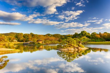 Japonya 'daki Okayama Korakuen Parkı' nda Kayo-no-ike Göleti ile geleneksel Japon Bahçesi. Altın Saat 'te Fotoğraf Çekildi. Yatay Resim Kompozisyonu
