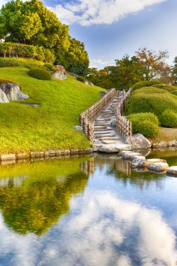 Japonya 'daki Okayama Korakuen Parkı' nda Kayo-no-ike Göleti ile geleneksel Japon Bahçesi. Altın Saat 'te Fotoğraf Çekildi. Dikey Çekim