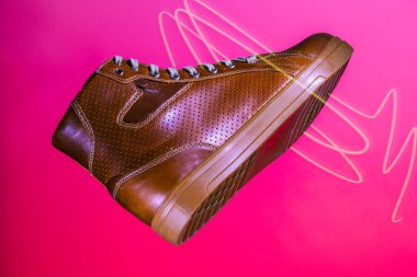 Motosikletçi Tan Deri Koruyucu Botlar 'ın yakın çekimi. Pembe Arka plan 'a karşı. Yatay Resim bileşimi