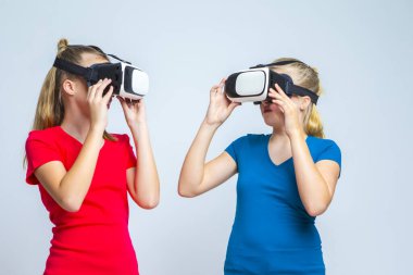 Sanal Gerçeklik Simülasyonu. Kafkas İkiz Kızlar VR ile Oynuyor (Sanal Gerçeklik) Miğferler Birlikte Kapalı Kapılar ardında. Yatay Görüntü Kompozisyonu