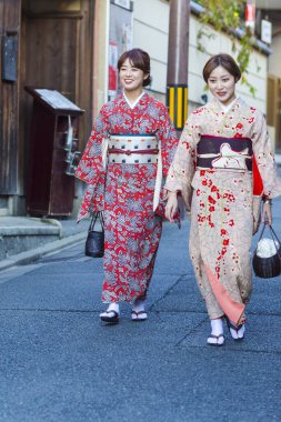 KYOTO, JAPONYA - 8, 2019: Kyoto, Japonya 'da Geleneksel Çevrede Çiçek İpek Kimono' da İki Güzel Japon Geyşası.