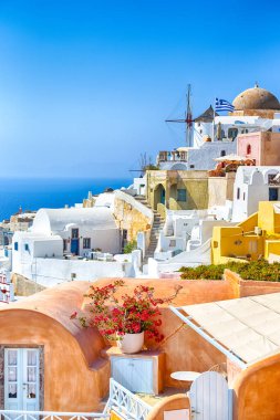 Yunanistan seyahati. Gündüz vakti Yunanistan 'ın Santorini Adası' ndaki Yunan Geleneksel Renkli Evleri ve Oia veya Ia Yel Değirmenleri manzarası. Dikey Çekim
