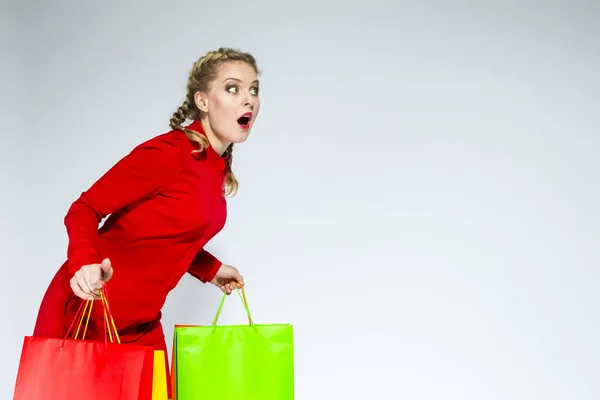 Shopping Ideas and Concepts. Portrait of Surprised Caucasian Girl  Posing With Plenty of Colorful Shopping Bags Against White Background. Horizontal image