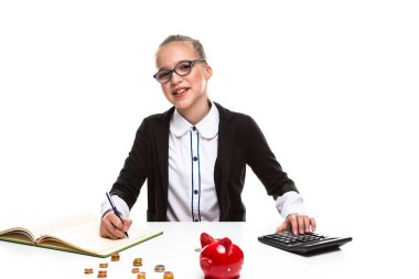 Çocuklar Tutumlu Kavramları. Gözlük takan mutlu sarışın genç kızın portresi. Bozuk para ve para kutusu ile poz vermek. Tasarruf için Para Hesaplayıcı ile Hesaplanıyor. Yatay Resim