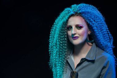 Yaratıcı Saç ve Makyaj Fikri. Kıvırcık saçlı ve siyahlara karşı sanatsal makyajlı sakin bir beyaz kız. Yatay Resim