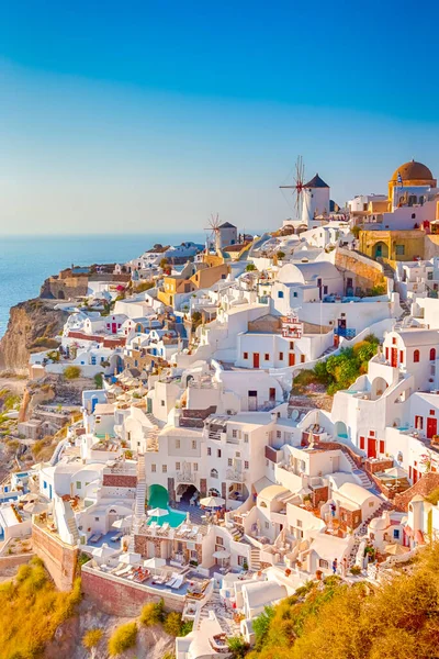 Traditional Colorful Houses and Windmills of Oia or Ia at Santorini Island at Noon. Vertical Image Orientation