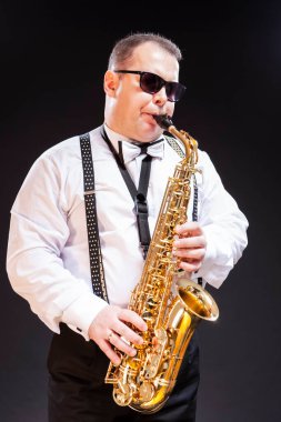Beyaz Gömlekli Beyaz Saksafoncu 'nun Dikensiz Siyah' a Karşı Güneş Gözlüklü Portresi. Dikey Yönlendirme