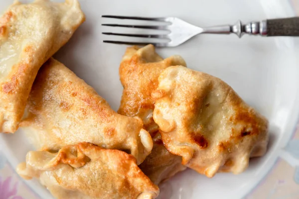 Stekta dumplings och gaffel på en tallrik. — Stockfoto