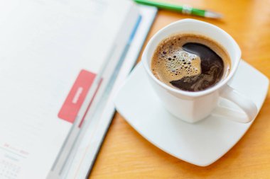 Tahta masanın üzerinde beyaz kahve fincanı..