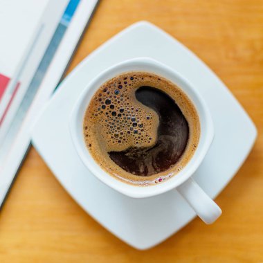 Tahta masanın üzerinde beyaz kahve fincanı..